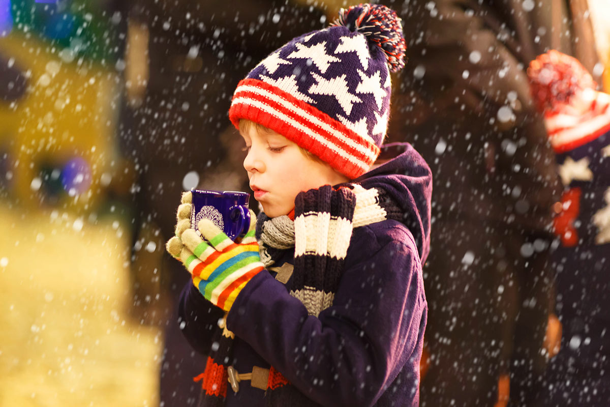 A young boy enjoys a warm cup of hot chocolate