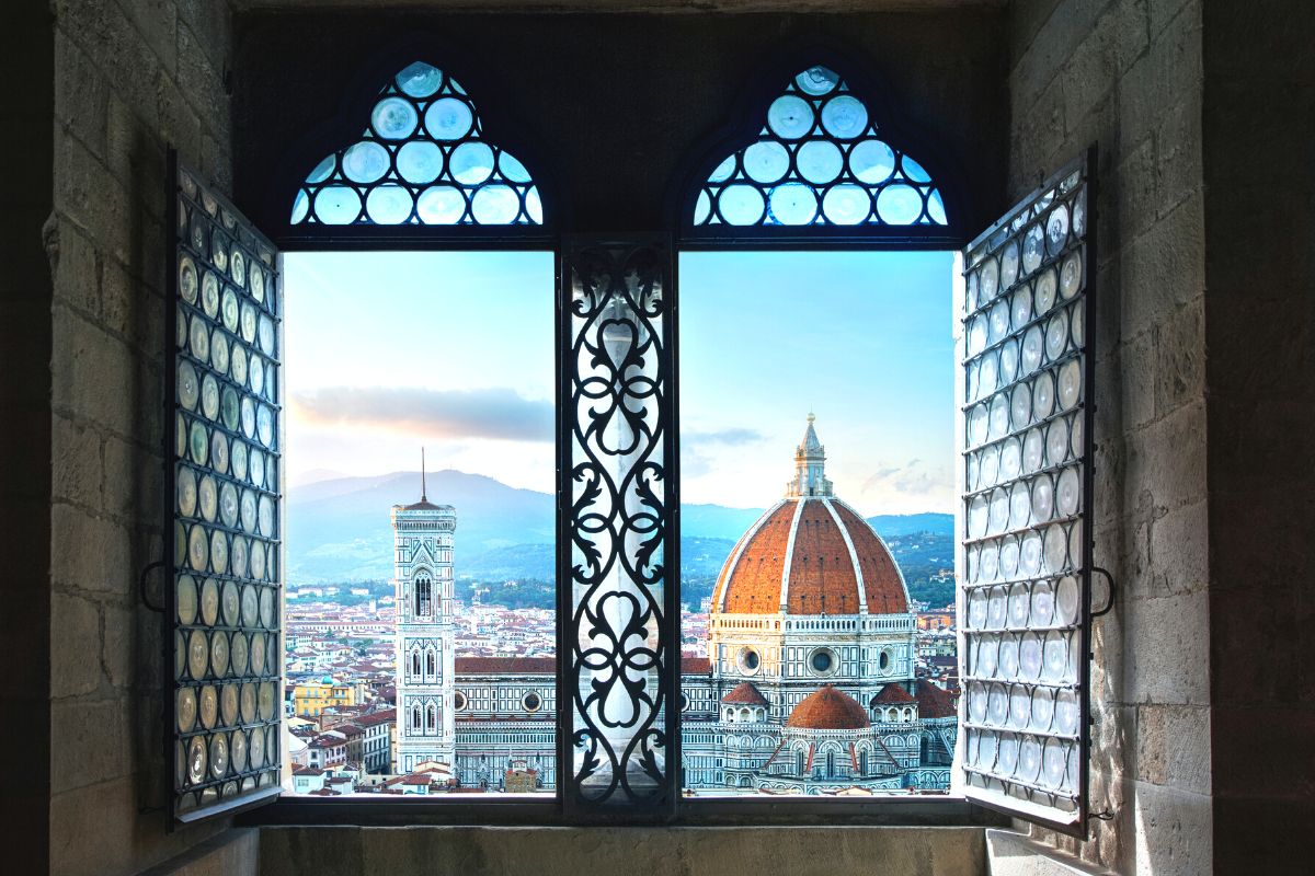 A panoramic view of the Duomo in Florence seen through old windows in a building