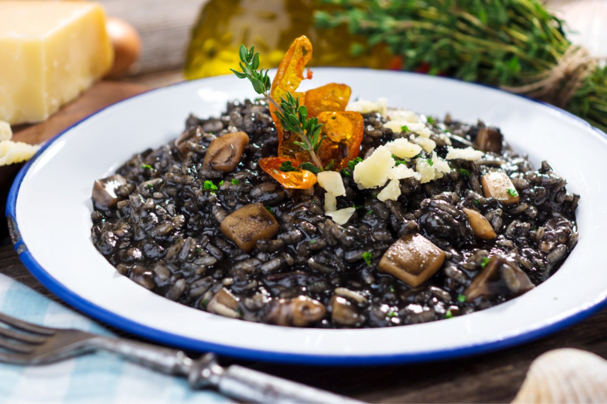 Crni rizot or black risotto, topped with parlsey and cheese