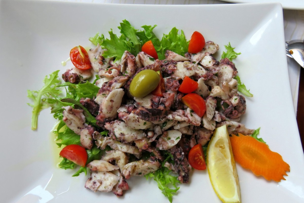 Plate of octopus salad or Salata od hobotnice with tomatoes and olives 